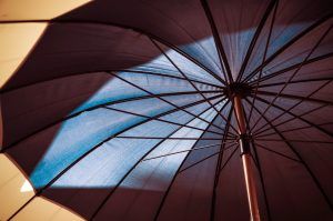 Close up image of the underside of a tan and black patio umbrella.