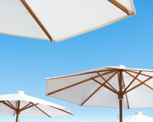 Three cantilever umbrellas open with a blue sky in the backdrop